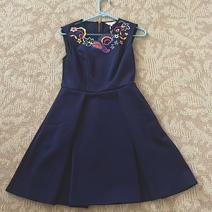 It has never been worn.  It has pockets a pleated skirt &  fitted bodice.